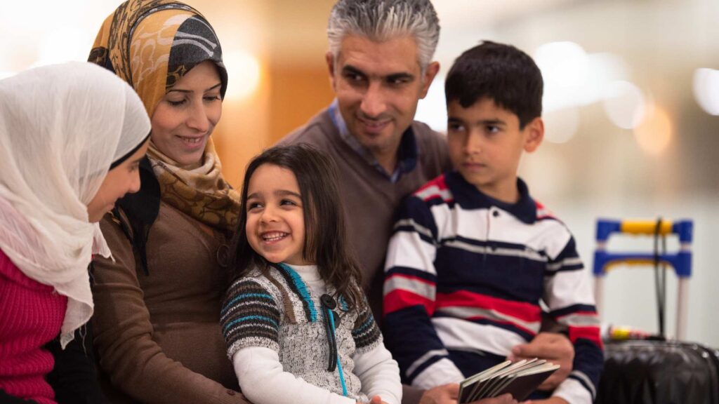 an imigrant family smiling in an airport