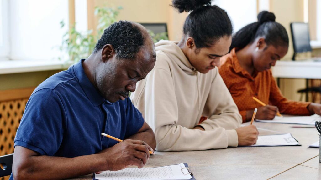 a group of new americans filling out paperwork
